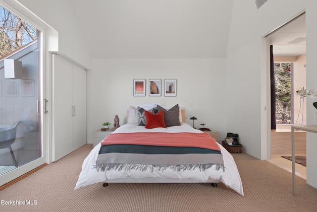 carpeted bedroom featuring access to exterior, a closet, and vaulted ceiling