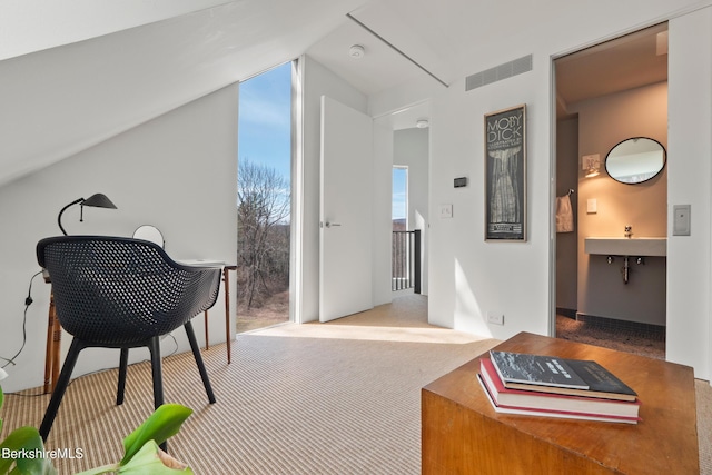 home office with carpet flooring, lofted ceiling, and visible vents