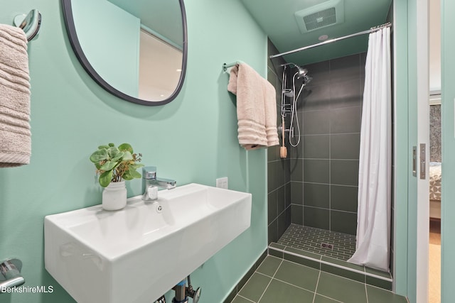 full bath with a shower stall, tile patterned flooring, visible vents, and a sink