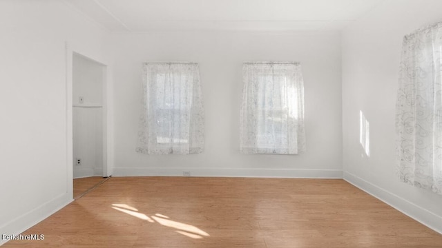 unfurnished room with light wood finished floors and baseboards