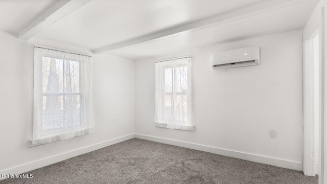 spare room with beamed ceiling, carpet flooring, an AC wall unit, and baseboards