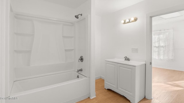 full bath featuring a sink, shower / bath combination, and wood finished floors