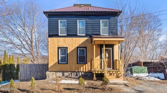 view of front of house with metal roof and fence