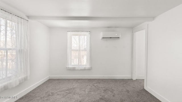 carpeted empty room featuring beamed ceiling, a wall mounted AC, and baseboards