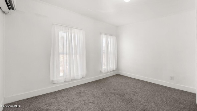spare room with baseboards, carpet, and a wall unit AC