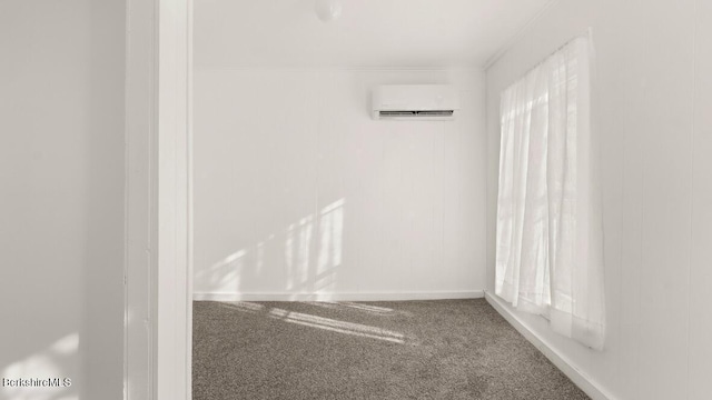 carpeted empty room featuring a wall mounted air conditioner and baseboards