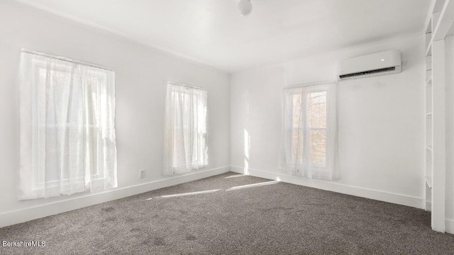 carpeted spare room with baseboards and a wall unit AC