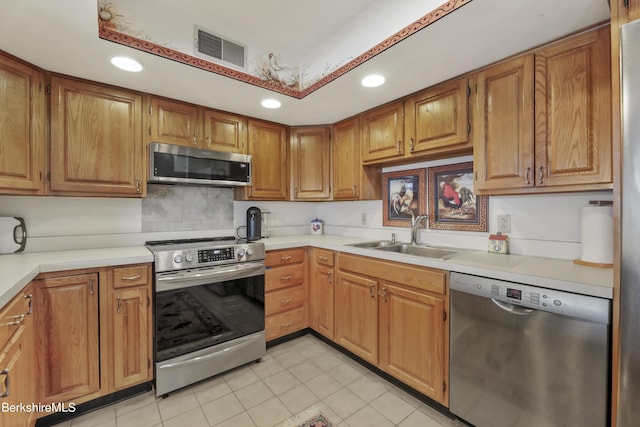 kitchen with stainless steel appliances, sink, and light tile patterned floors