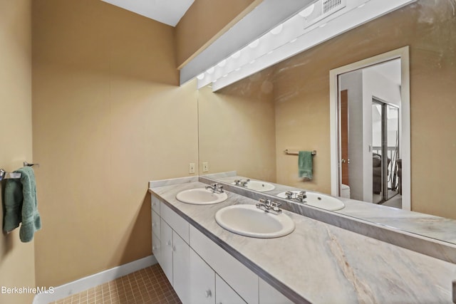 bathroom featuring vanity, tile patterned flooring, and toilet