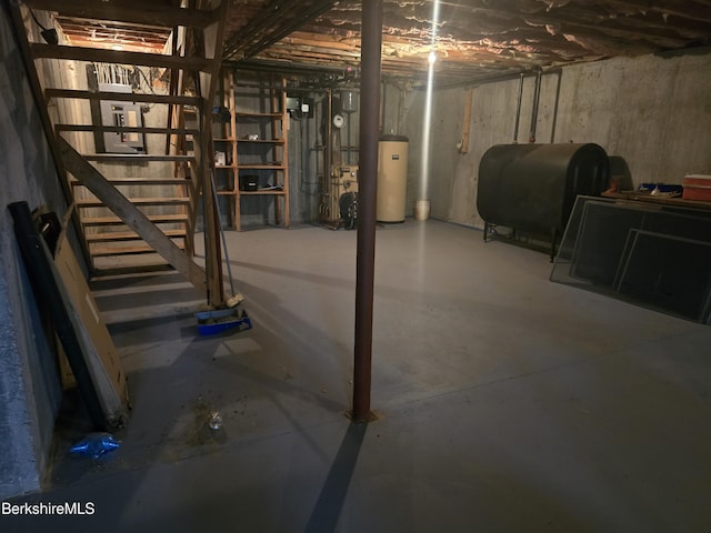 unfinished basement with stairway, heating fuel, and water heater