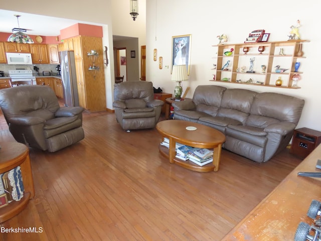 living room featuring light wood-style floors and a high ceiling