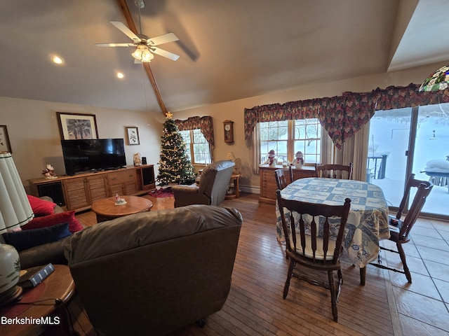 living room with ceiling fan, hardwood / wood-style floors, and vaulted ceiling