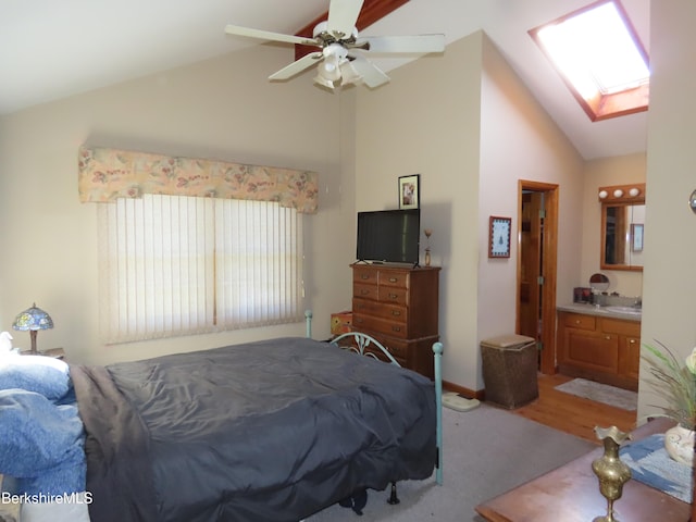 bedroom with ensuite bathroom, ceiling fan, and lofted ceiling with skylight