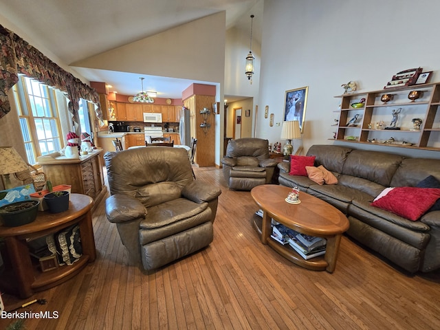 living room featuring light wood-type flooring and high vaulted ceiling