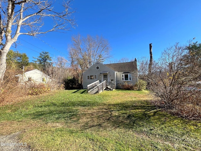 rear view of house featuring a lawn