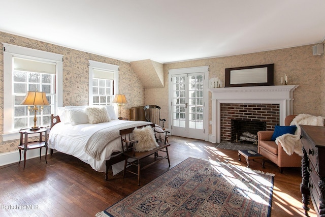 bedroom with a fireplace with flush hearth, wallpapered walls, baseboards, and wood-type flooring