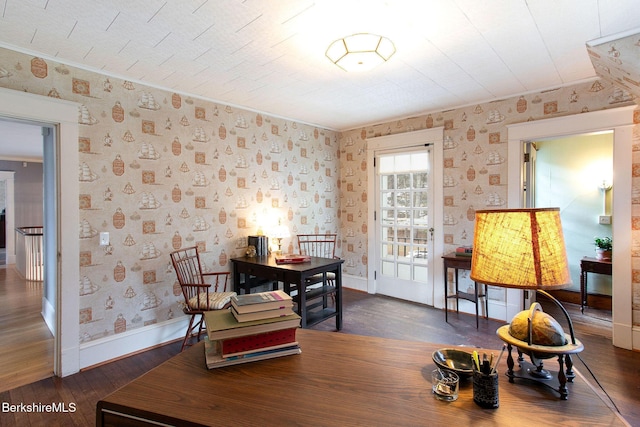 dining room featuring wallpapered walls, dark wood finished floors, and baseboards