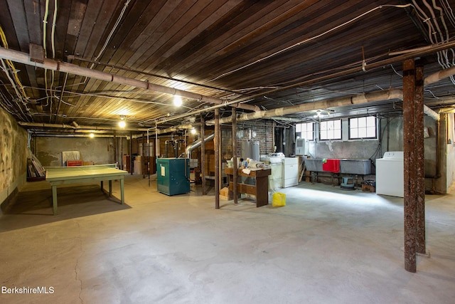 basement with washing machine and clothes dryer and a heating unit