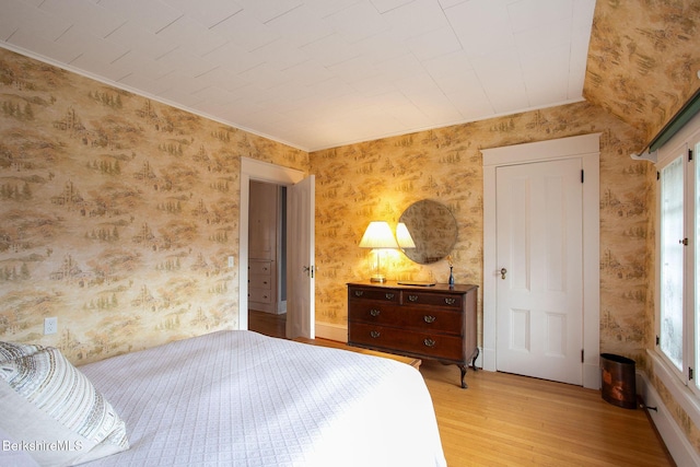 bedroom with wallpapered walls and light wood-type flooring