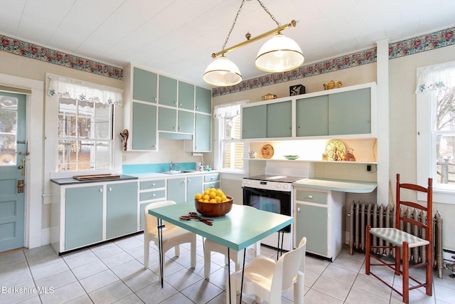 kitchen featuring electric range, open shelves, radiator, green cabinetry, and light tile patterned floors