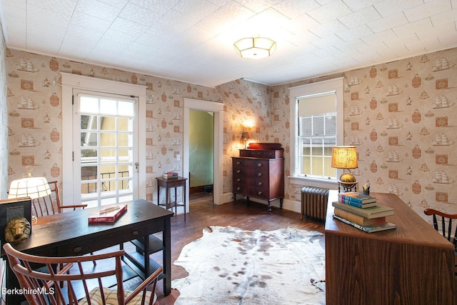 interior space with baseboards, radiator, wood finished floors, and wallpapered walls