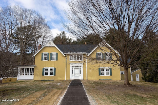 traditional home with stucco siding and a front lawn