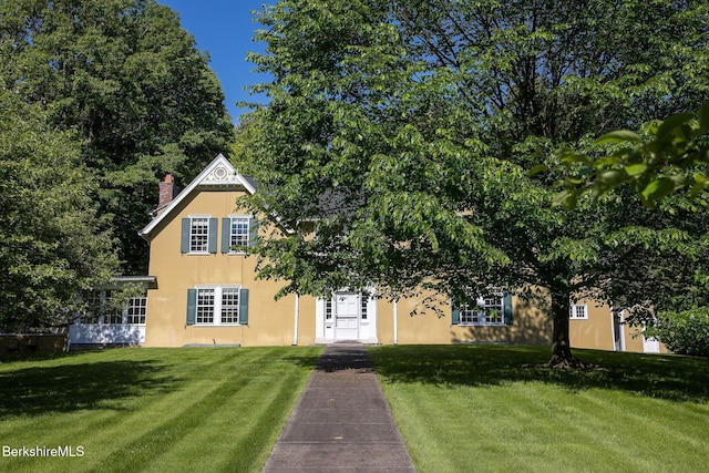 82 W Ave, Great Barrington, MA 01230 - view of front of property with stucco siding, a front yard, and a chimney