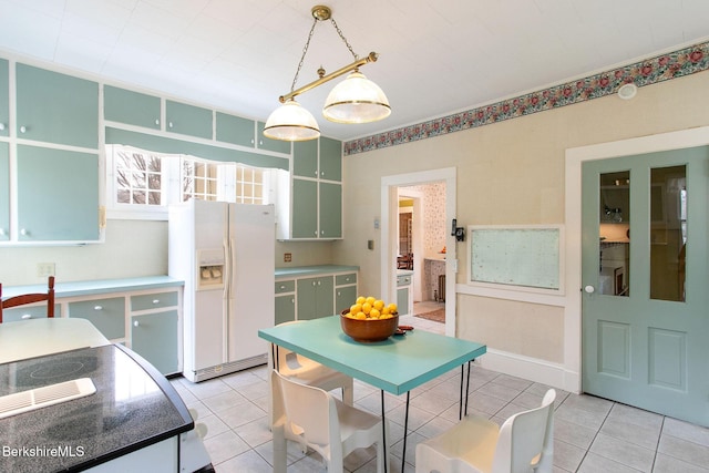 kitchen with white refrigerator with ice dispenser, light tile patterned flooring, and pendant lighting