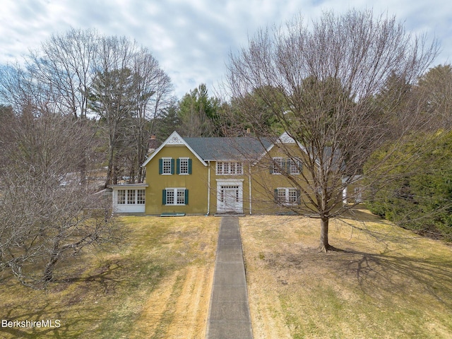 view of front of house featuring stucco siding, french doors, and a front lawn