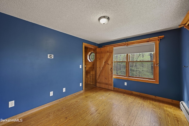189 Cross Place Rd, Washington, MA 01223 - unfurnished room with baseboards, hardwood / wood-style floors, a textured ceiling, and a baseboard heating unit
