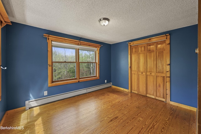 189 Cross Place Rd, Washington, MA 01223 - unfurnished bedroom featuring a baseboard heating unit, a textured ceiling, wood finished floors, baseboards, and a closet