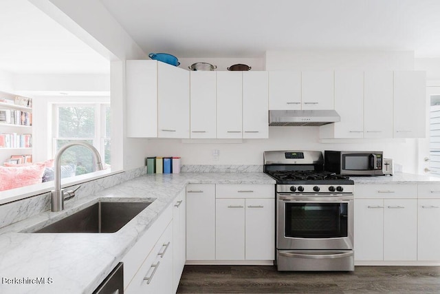 80 Taconic Ave # 14, Great Barrington, MA 01230 - kitchen with appliances with stainless steel finishes, exhaust hood, dark wood-type flooring, light stone counters, and white cabinets