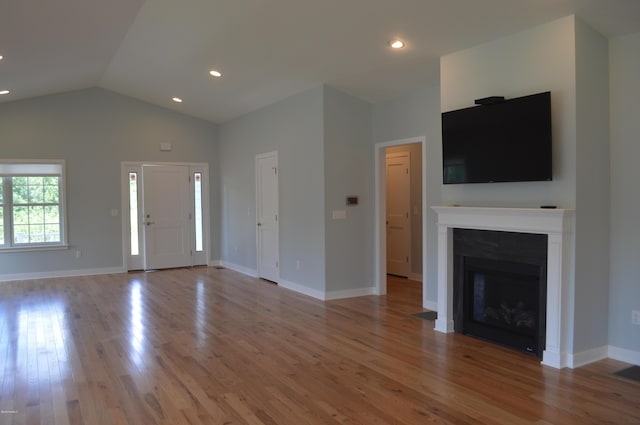 unfurnished living room with light hardwood / wood-style flooring and lofted ceiling