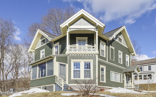 victorian-style house featuring entry steps and a balcony