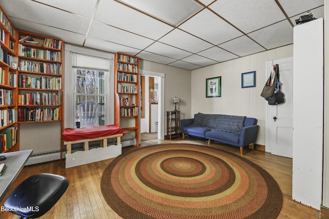 sitting room featuring a paneled ceiling and wood-type flooring