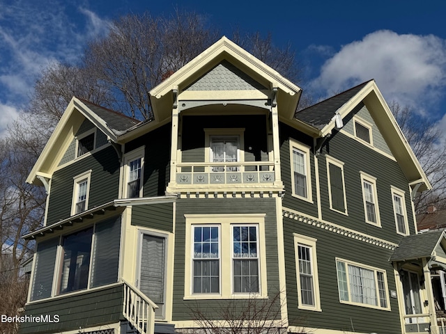 victorian-style house featuring a balcony and entry steps