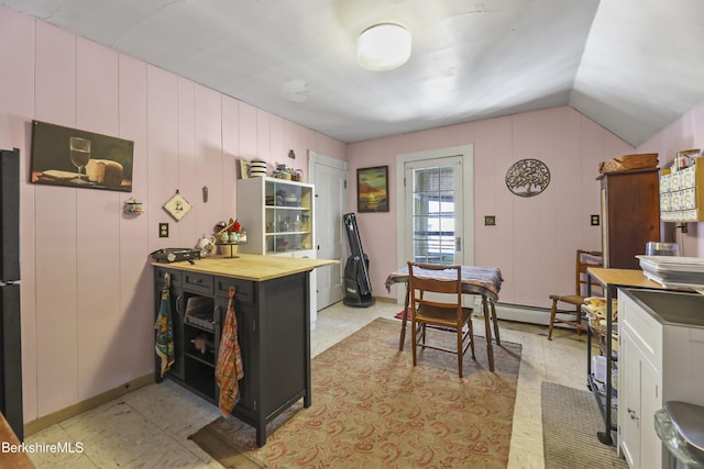 kitchen with wooden counters, a baseboard heating unit, and lofted ceiling