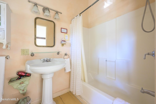 bathroom featuring sink and shower / bath combination with curtain