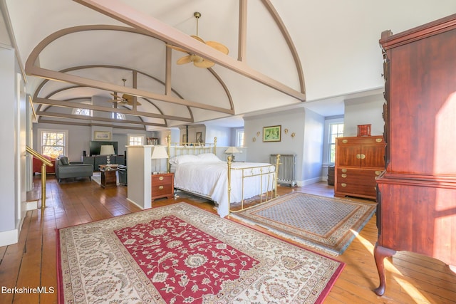 bedroom with hardwood / wood-style floors and high vaulted ceiling