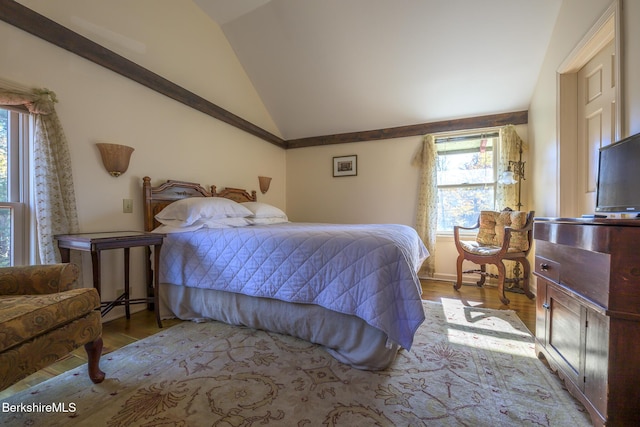 bedroom featuring lofted ceiling, light hardwood / wood-style flooring, and a baseboard heating unit