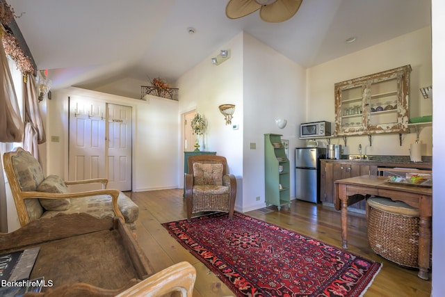 living room featuring wood-type flooring, vaulted ceiling, ceiling fan, and sink