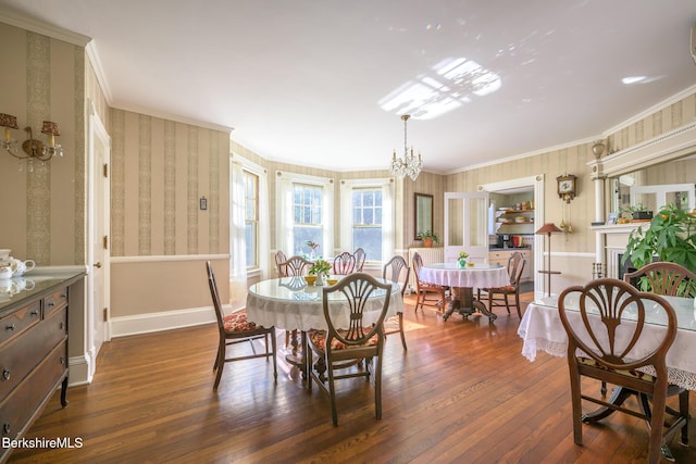 dining area with dark hardwood / wood-style flooring, an inviting chandelier, and crown molding