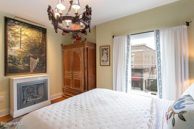 34 Bridge St, Great Barrington, MA 01230 - bedroom featuring a chandelier, wood finished floors, and a fireplace