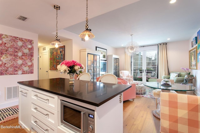 34 Bridge St, Great Barrington, MA 01230 - kitchen with stainless steel microwave, light wood-style floors, white cabinets, dark countertops, and recessed lighting