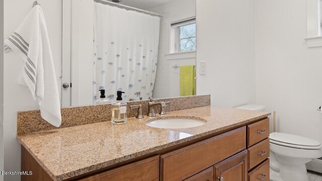 bathroom with toilet, vanity, and a shower with curtain
