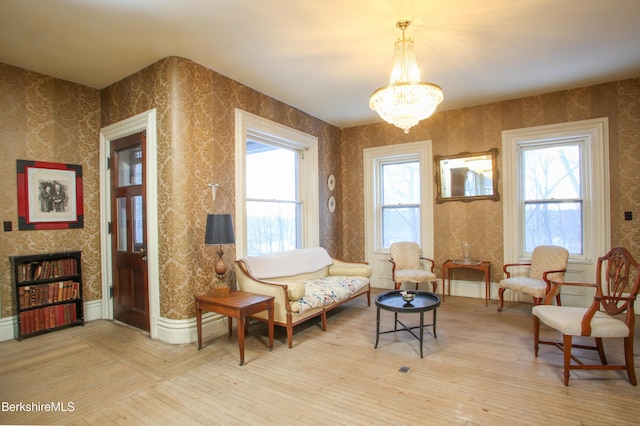 living area featuring a notable chandelier and light wood-type flooring