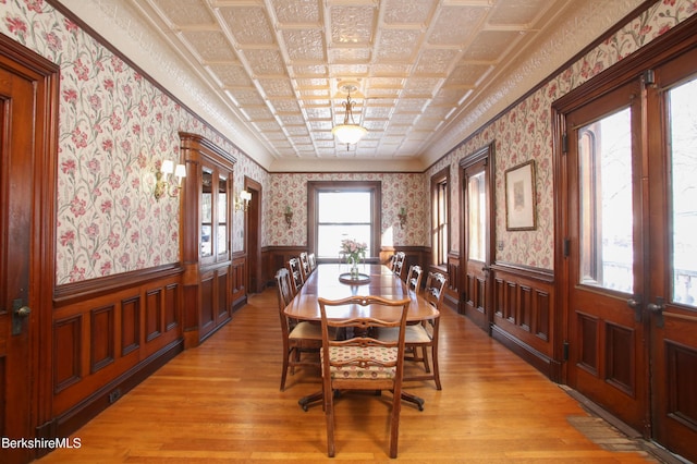 dining space with light hardwood / wood-style flooring and ornamental molding