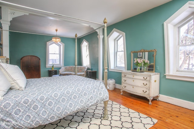 bedroom featuring multiple windows and hardwood / wood-style flooring