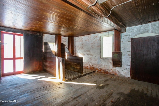 unfurnished room featuring brick wall, hardwood / wood-style flooring, and wooden ceiling