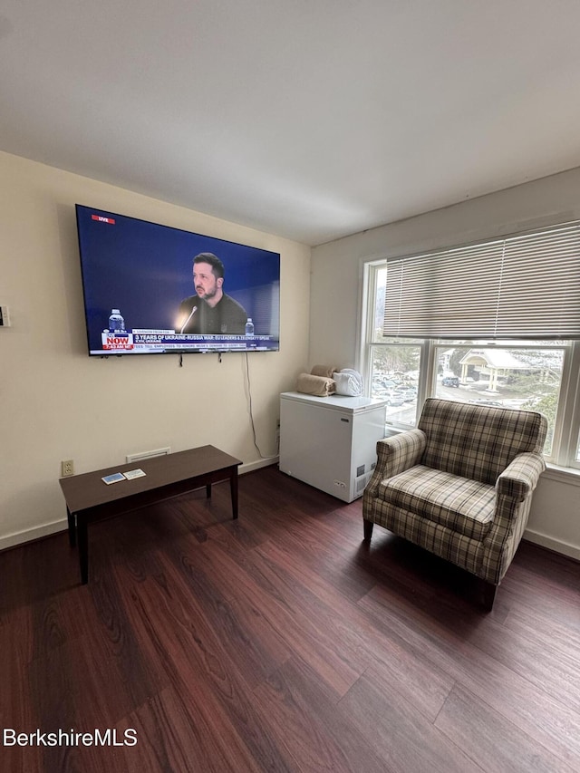 living area with baseboards and wood finished floors